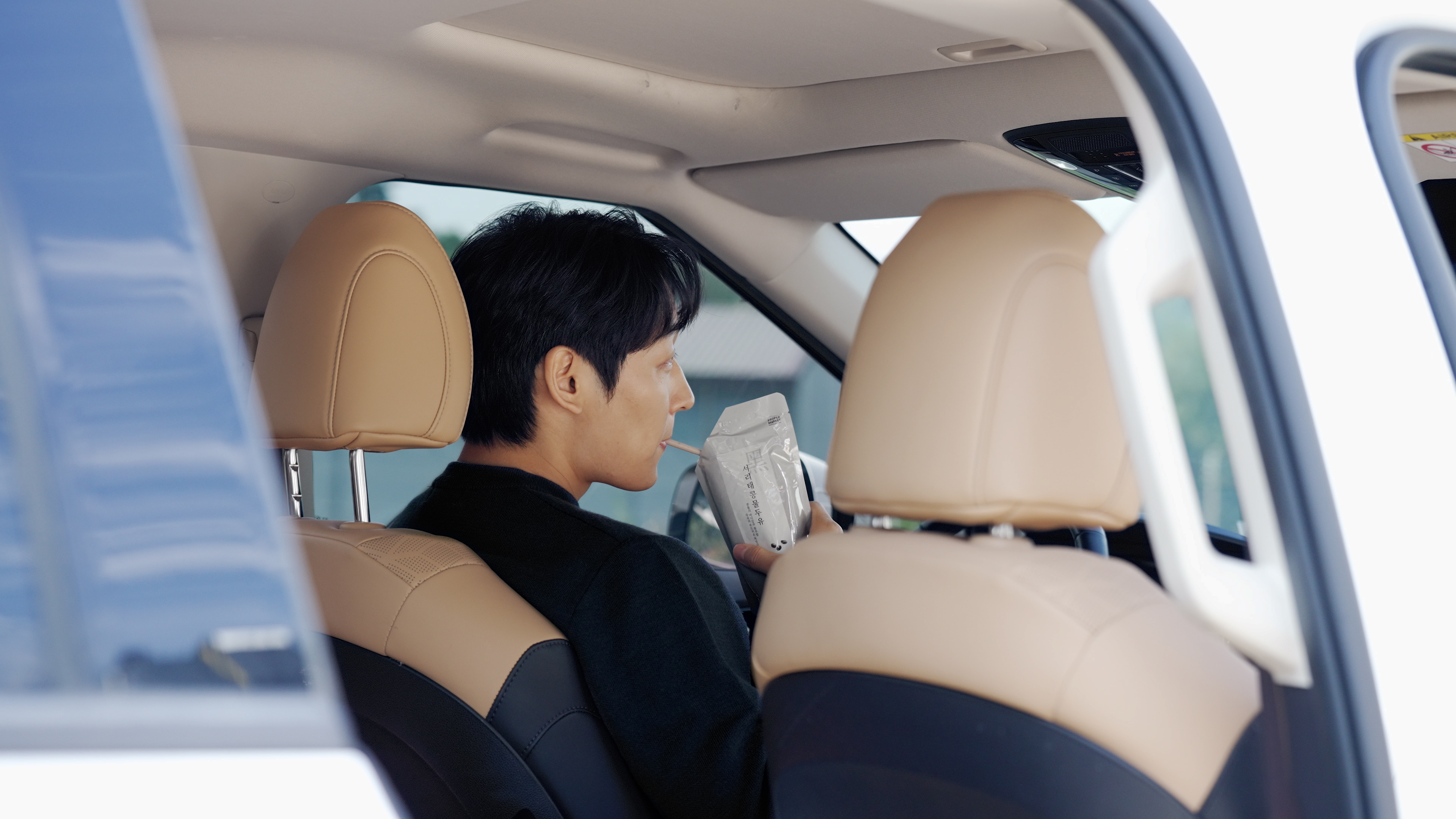 출근길 차 안에서 서리태콩물두유를 마시는 모습